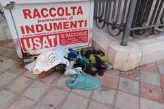 Contenitore indumenti saccheggiato: scarpe e vestiti a terra in piazza Garibaldi