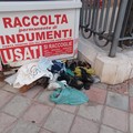 Contenitore indumenti saccheggiato: scarpe e vestiti a terra in piazza Garibaldi