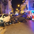 Sbandano e finiscono contro le auto in sosta, la vettura si ribalta: illesi
