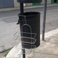 Una griglia per doccia abbandonata su un cestino portarifiuti