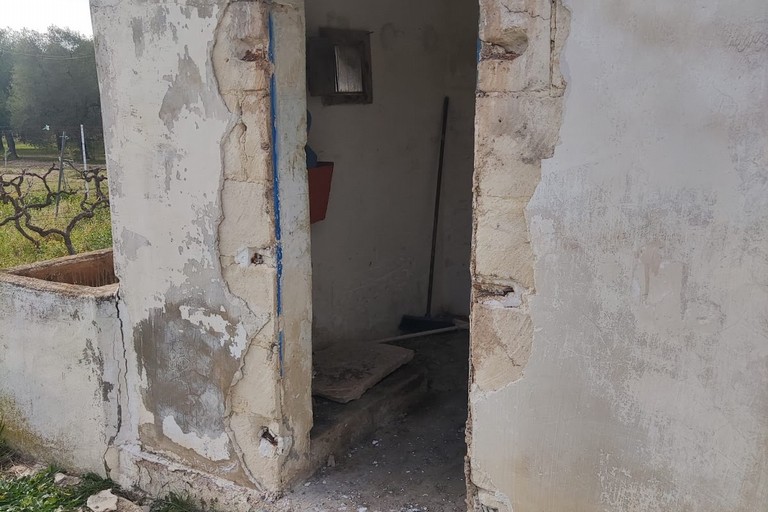 Una porta in ferro divelta e rubata