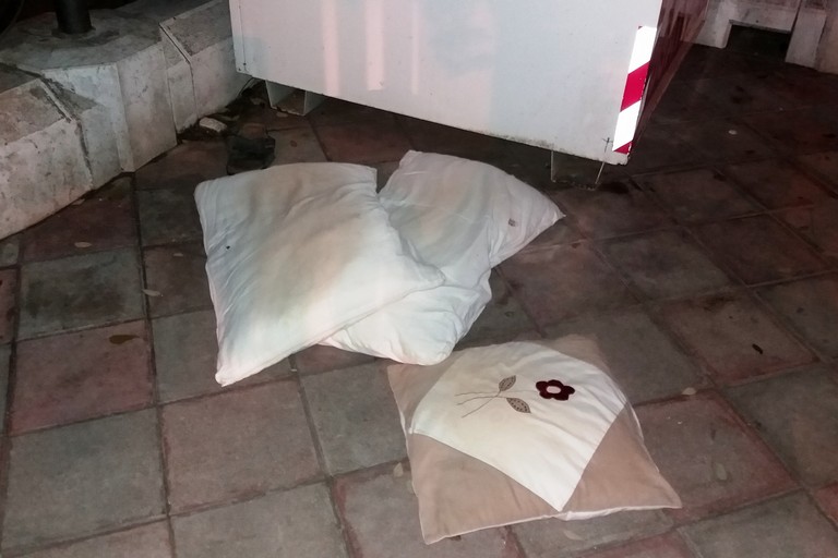 Cuscini lasciati per terra vicino il contenitore per indumenti. <span>Foto Gianluca Battista</span>